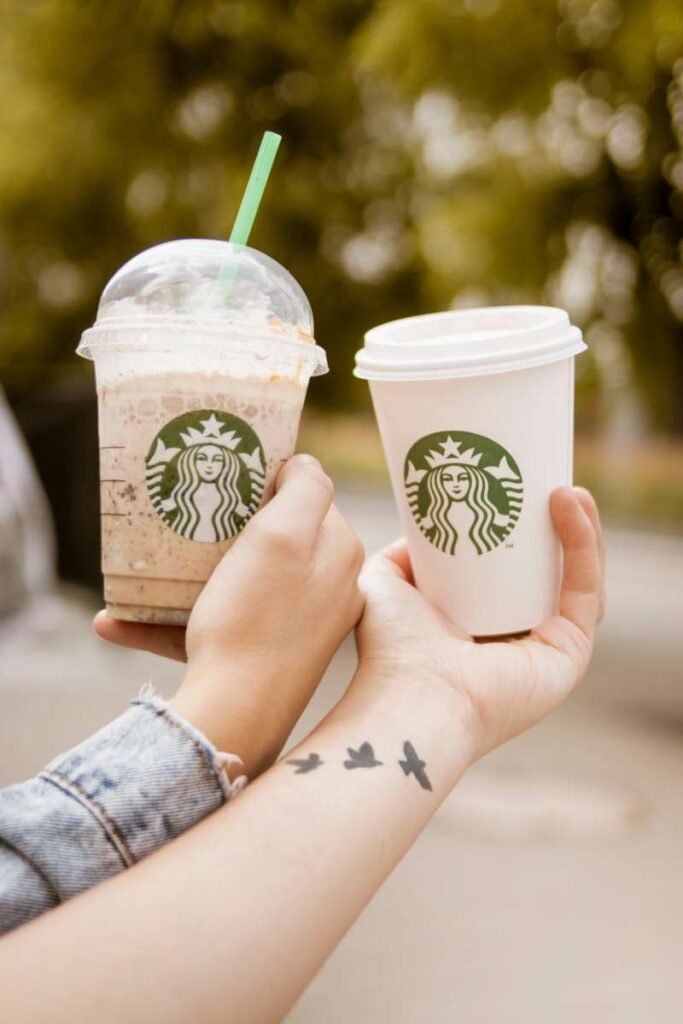 Starbucks two cups held by a couple, with a white girl's left hand featuring a tattoo. Visit Vedic Trend Tattoo shop to customize your unique design.