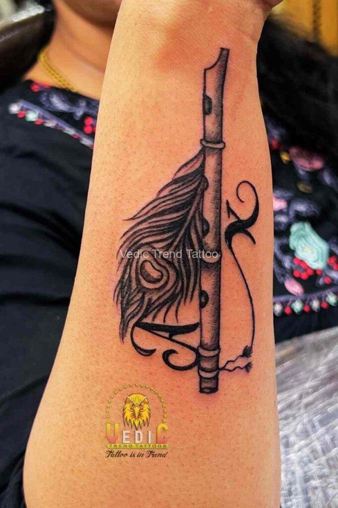 Feather with flute letter K tattoo